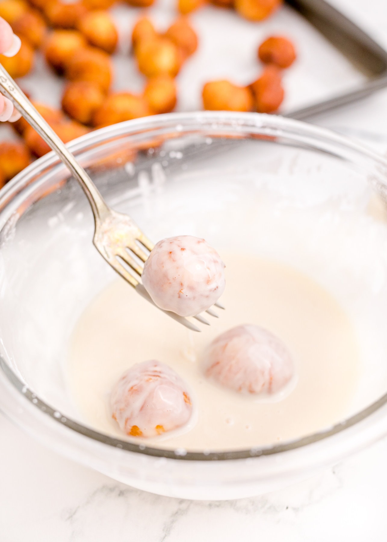 coating the donuts in a glaze.